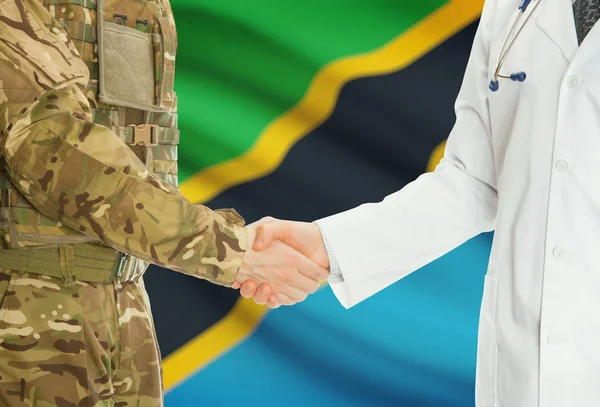 Military man in uniform and doctor shaking hands with national flag on background - Tanzania — Stock Photo, Image