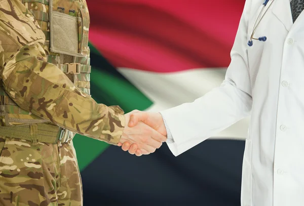 Homme militaire en uniforme et le médecin se serrant la main avec le drapeau national sur le fond - Soudan — Photo