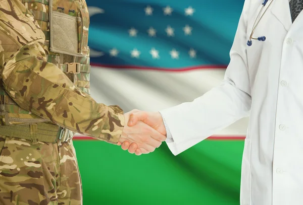 Military man in uniform and doctor shaking hands with national flag on background - Uzbekistan — Stok fotoğraf