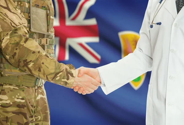 Military man in uniform and doctor shaking hands with national flag on background - Turks and Caicos Islands — Stock fotografie