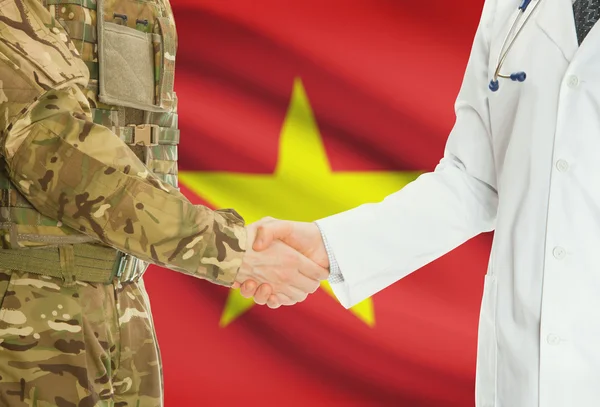 Military man in uniform and doctor shaking hands with national flag on background - Vietnam — Foto Stock