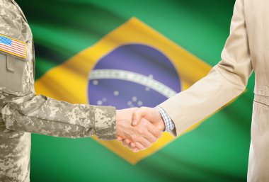 USA military man in uniform and civil man in suit shaking hands with national flag on background - Brazil