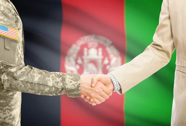 Usa militaire en uniforme et l'homme en costume civil serrant la main avec le drapeau national sur le fond - Afghanistan — Photo