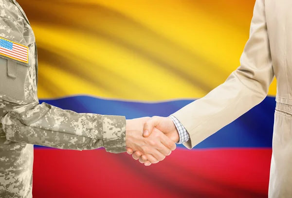 USA military man in uniform and civil man in suit shaking hands with national flag on background - Colombia — Foto de Stock
