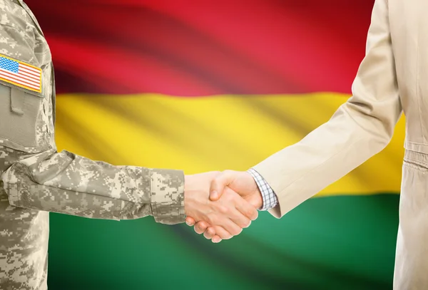 USA military man in uniform and civil man in suit shaking hands with national flag on background - Bolivia — Stockfoto