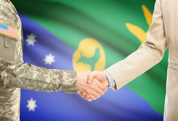 USA military man in uniform and civil man in suit shaking hands with national flag on background - Christmas Island — Stockfoto