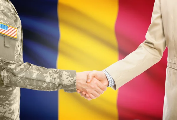 USA military man in uniform and civil man in suit shaking hands with national flag on background - Chad — Zdjęcie stockowe
