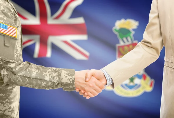 USA military man in uniform and civil man in suit shaking hands with national flag on background - Cayman Islands — Stockfoto