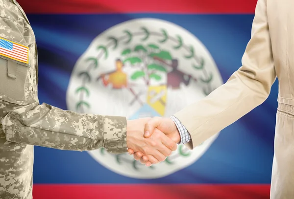 USA military man in uniform and civil man in suit shaking hands with national flag on background - Belize —  Fotos de Stock