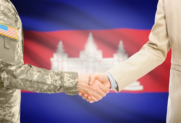 США военный человек в военной форме и гражданской мужчина в костюме, рукопожатие с национальным флагом на фоне - Камбоджа — стоковое фото