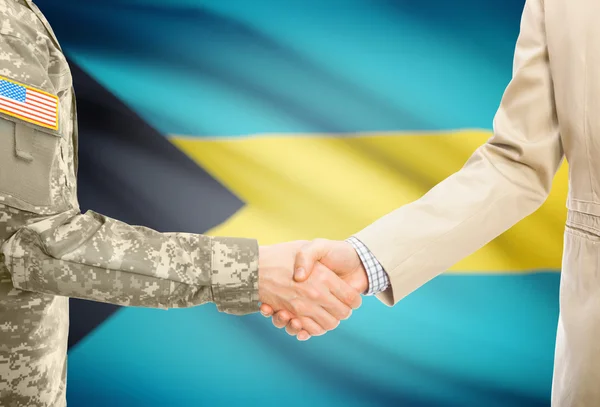 USA military man in uniform and civil man in suit shaking hands with national flag on background - Bahamas — Zdjęcie stockowe