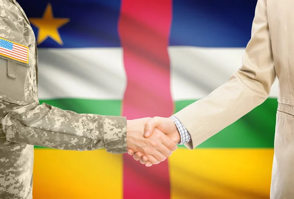 USA military man in uniform and civil man in suit shaking hands with national flag on background - Central African Republic —  Fotos de Stock