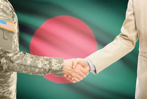 USA military man in uniform and civil man in suit shaking hands with national flag on background - Bangladesh — Stockfoto