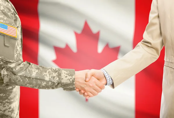 Usa militaire en uniforme et l'homme en costume civil serrant la main avec le drapeau national sur le fond - Canada — Photo