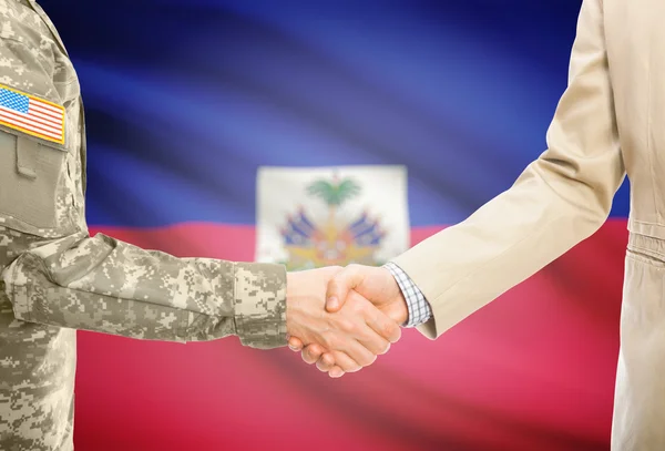 USA military man in uniform and civil man in suit shaking hands with national flag on background - Haiti — Foto de Stock
