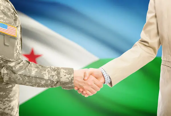 USA military man in uniform and civil man in suit shaking hands with national flag on background - Djibouti — Stock fotografie