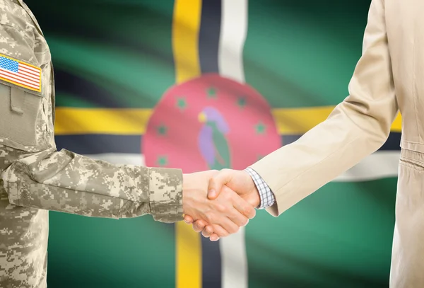 USA military man in uniform and civil man in suit shaking hands with national flag on background - Dominica — Stock fotografie