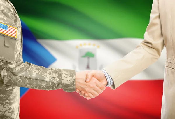 USA military man in uniform and civil man in suit shaking hands with national flag on background - Equatorial Guinea — Stockfoto