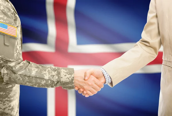 USA military man in uniform and civil man in suit shaking hands with national flag on background - Iceland — 图库照片