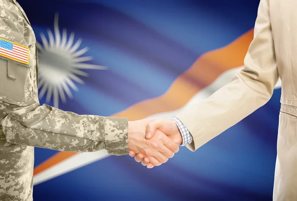 USA military man in uniform and civil man in suit shaking hands with national flag on background - Marshall Islands — Stockfoto