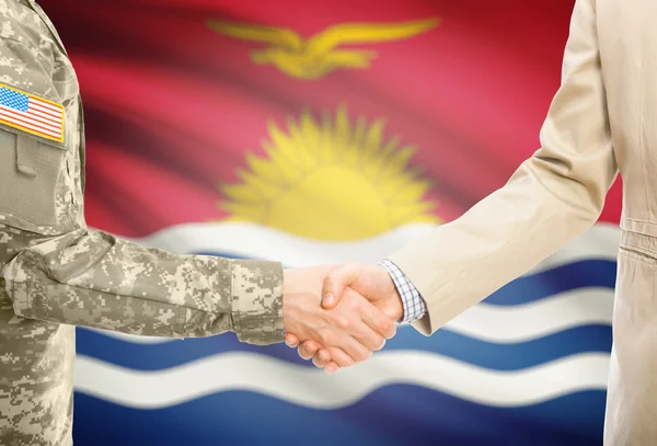 USA military man in uniform and civil man in suit shaking hands with national flag on background - Kiribati — Stockfoto