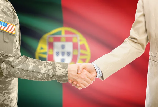 USA military man in uniform and civil man in suit shaking hands with national flag on background - Portugal — Stockfoto