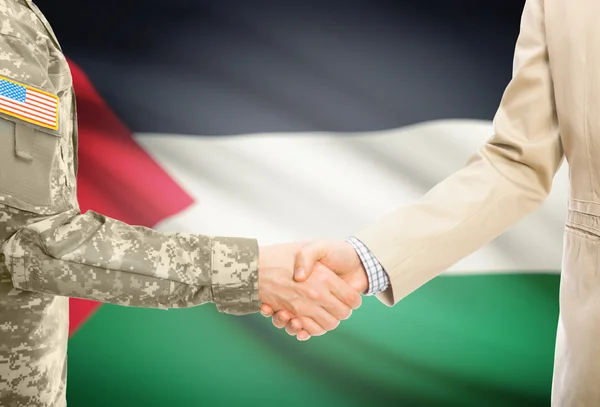 Usa militaire en uniforme et l'homme en costume civil serrant la main avec le drapeau national sur le fond - Palestine — Photo