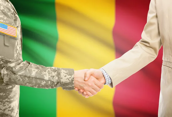 США военный человек в военной форме и гражданской мужчина в костюме, рукопожатие с национальным флагом на фоне - Мали — стоковое фото