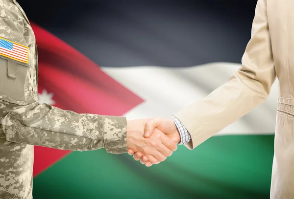 USA military man in uniform and civil man in suit shaking hands with national flag on background - Jordan — Stockfoto