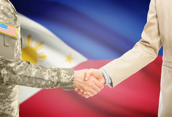 USA military man in uniform and civil man in suit shaking hands with national flag on background - Philippines — Stok fotoğraf