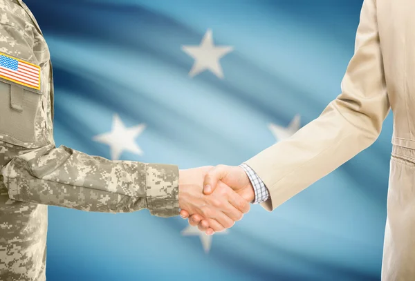 USA military man in uniform and civil man in suit shaking hands with national flag on background - Micronesia — Stock Photo, Image