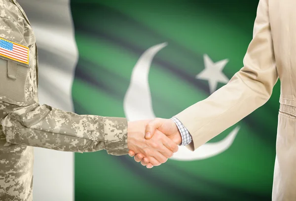 USA military man in uniform and civil man in suit shaking hands with national flag on background - Pakistan — Stock Photo, Image