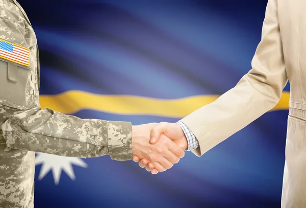 USA military man in uniform and civil man in suit shaking hands with national flag on background - Nauru — Stock fotografie