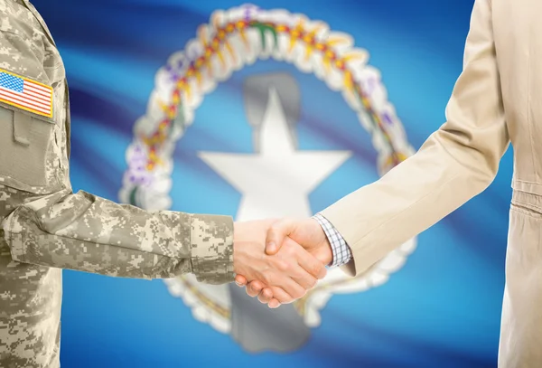 USA military man in uniform and civil man in suit shaking hands with national flag on background - Northern Mariana Islands — стокове фото