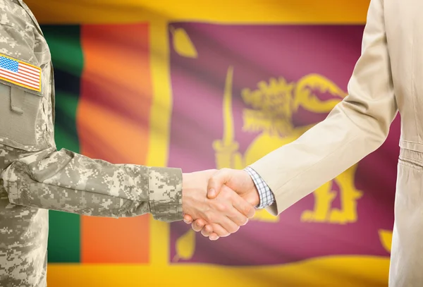 USA military man in uniform and civil man in suit shaking hands with national flag on background - Sri Lanka — Stockfoto