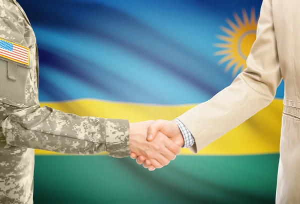 VS militaire man in uniform en burgerlijke man in pak handen schudden met nationale vlag op de achtergrond - Rwanda — Stockfoto