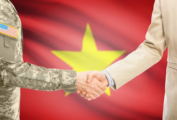 Wojskowy USA w jednolite i obywatelskiego człowieka w zależności od drżenie rąk z flagi narodowej na tle - Wietnam — Zdjęcie stockowe