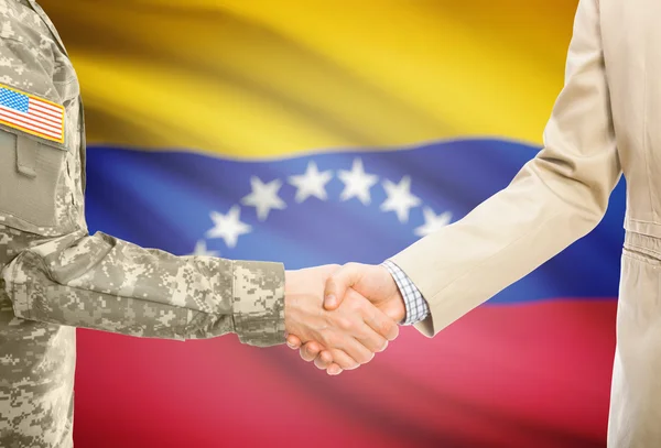 Hombre militar de usa en uniforme y civil hombre en traje sacudiendo las manos con bandera nacional de fondo - Venezuela — Foto de Stock