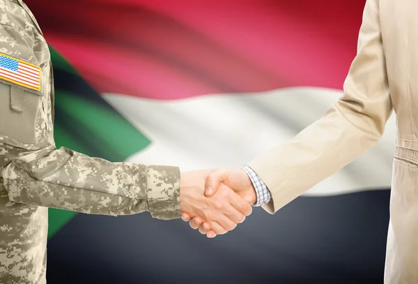 USA military man in uniform and civil man in suit shaking hands with national flag on background - Sudan — Stock Photo, Image