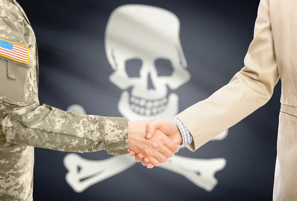 USA military man in uniform and civil man in suit shaking hands with flag on background - Jolly Roger - symbol of piracy — 图库照片