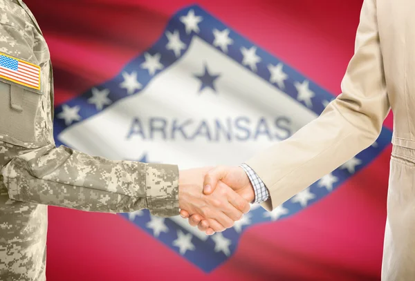 USA military man in uniform and civil man in suit shaking hands with USA state flag on background - Arkansas —  Fotos de Stock