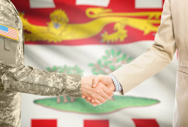 Homem militar de EUA em homem de uniforme e civil em adequar o aperto de mãos com a bandeira da província canadense em fundo - ilha do Príncipe Eduardo — Fotografia de Stock