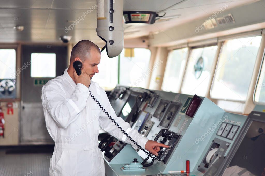 Sailor navigator, the third assistant to the captain in a white overalls on the captains bridge.