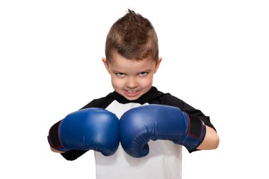 Kafasında mavi boks eldiveni ve siyah-beyaz tişörtü olan, çok kötü görünüşlü, küçük, sportif bir çocuk..