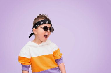 Şık giyinmiş, güneş gözlüklü havalı çocuk çığlıklar atıyor..