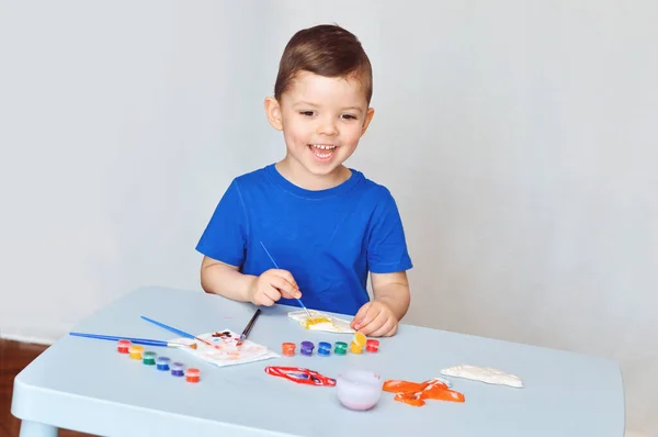 Liten Pojke Blå Shirt Målar Gips Figurerar Magneter Med Akrylfärger — Stockfoto