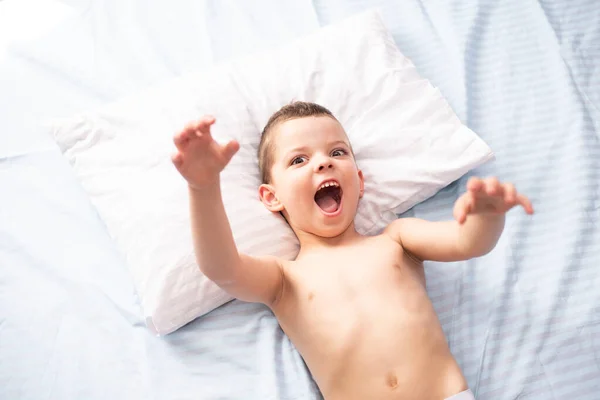 Μικρό Χαριτωμένο Αγόρι Παίζει Ενώ Βρίσκεται Στο Κρεβάτι — Φωτογραφία Αρχείου