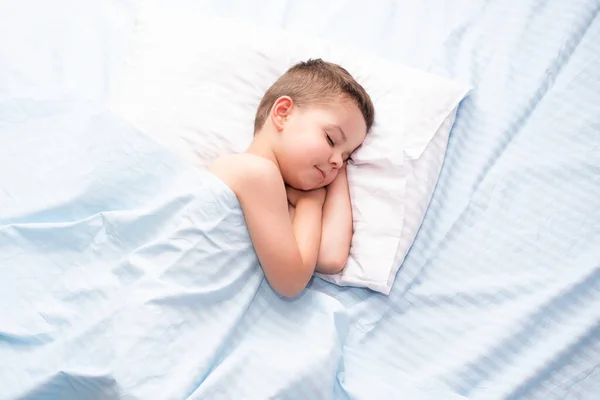 かわいいです4 5歳の幼児男の子寝静かに上の新鮮な青寝具とともに白い枕 — ストック写真