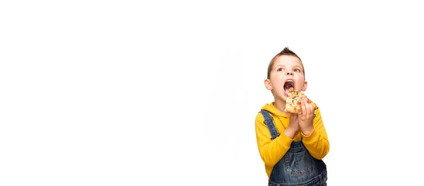 Mały Słodki Chłopiec Żółtym Swetrze Dżinsowych Kombinezonach Trzyma Kawałek Pizzy — Zdjęcie stockowe
