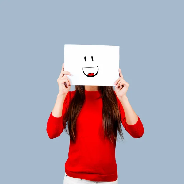 Ragazza in possesso di una carta con un volto felice dipinto isolato su bianco — Foto Stock
